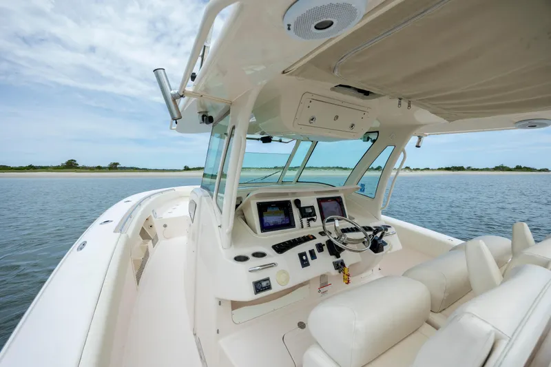 Slide: The Image of 2011 Grady-White Canyon 366 boat interior with helm, steering wheel, and navigation screens. - 21