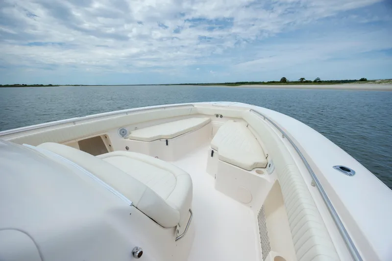 Slide: The Image of 2011 Grady-White Canyon 366 boat interior with seating, on calm water under a cloudy sky. - 22