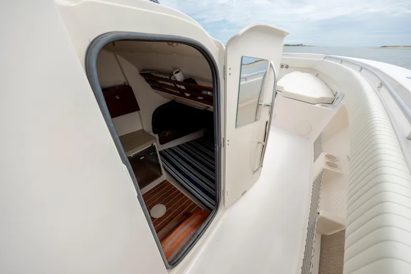 Slide: The Image of 2011 Grady-White Canyon 366 boat cabin interior with open door, showcasing seating and storage. - 24