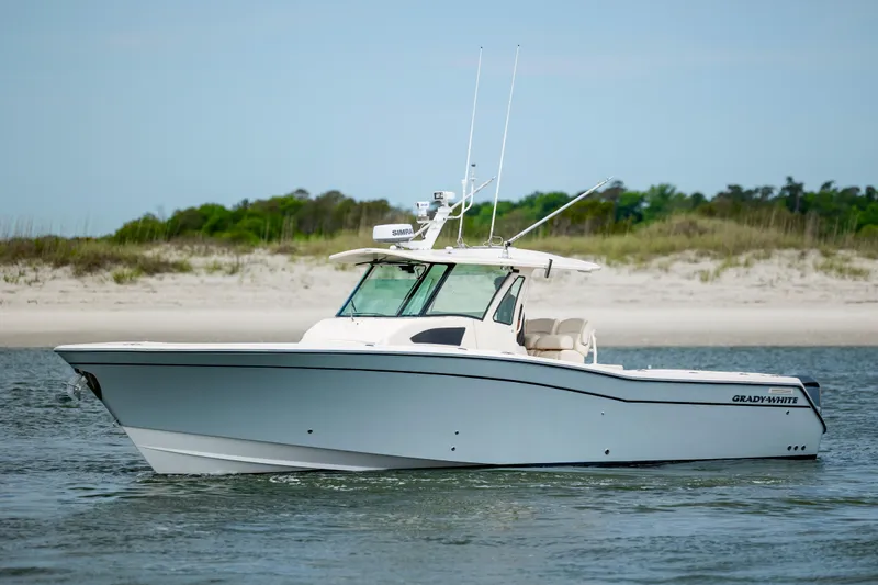 Slide: The Image of 2011 Grady-White Canyon 366 boat on water near sandy shoreline. - 3
