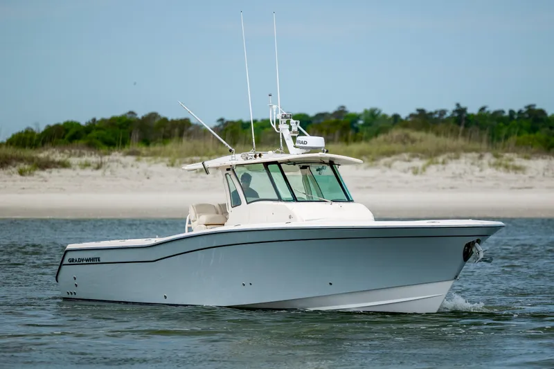Slide: The Image of 2011 Grady-White Canyon 366 boat cruising near a sandy shoreline. - 5