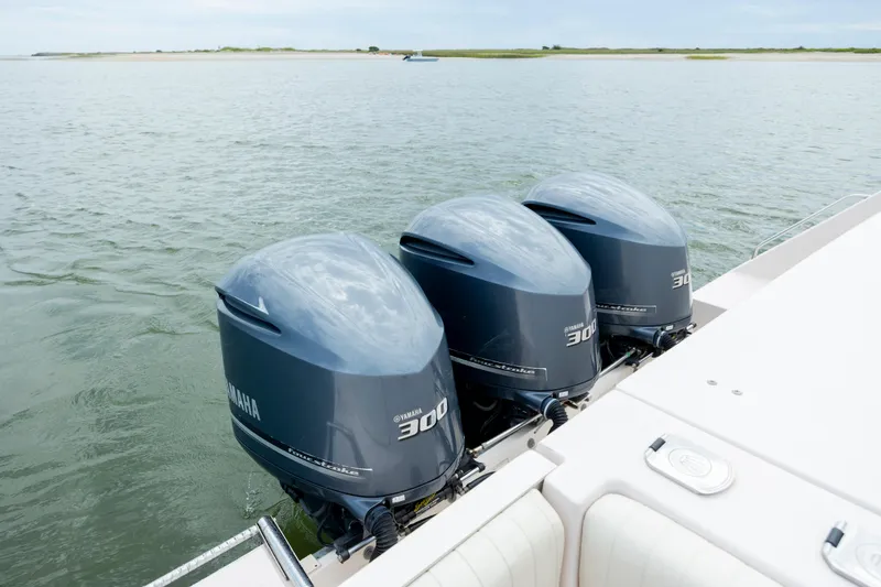 Slide: The Image of Triple Yamaha 300 engines on a 2011 Grady-White Canyon 366 boat in calm waters. - 8