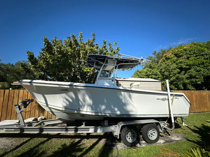 Slide: The Image of 2005 Sailfish 2360 CC boat on trailer, parked in a sunny yard. - 1