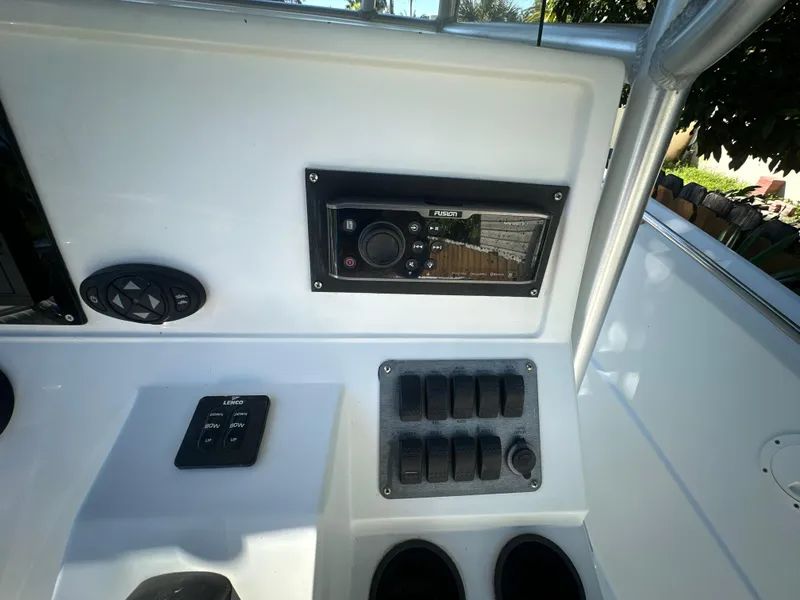 Slide: The Image of Control panel of a 2005 Sailfish 2360 CC boat with switches and a stereo system. - 12