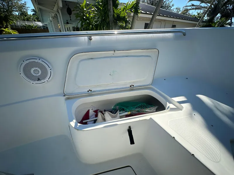 Slide: The Image of Open storage compartment on 2005 Sailfish 2360 CC boat deck, with gear inside. - 17
