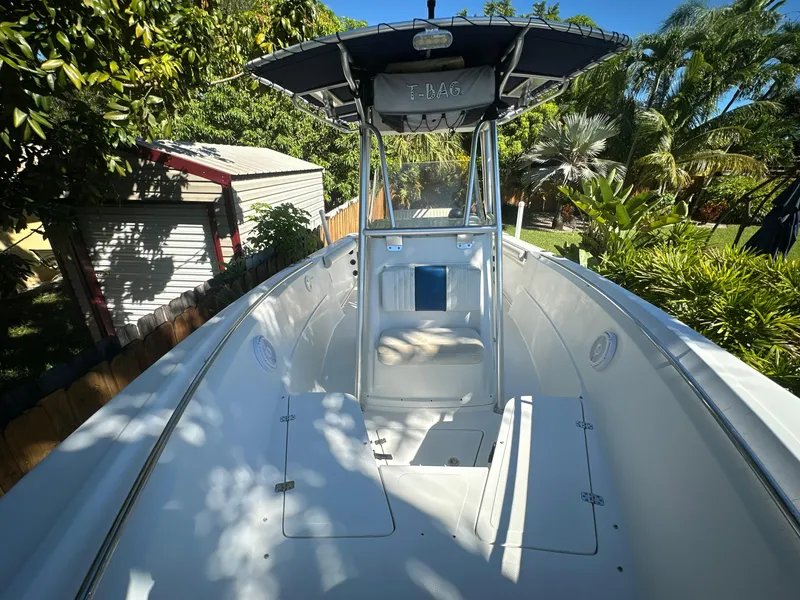 Slide: The Image of 2005 Sailfish 2360 CC boat with T-top, surrounded by lush greenery. - 20