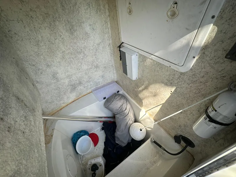 Slide: The Image of 2005 Sailfish 2360 CC boat interior with storage items and equipment. - 24