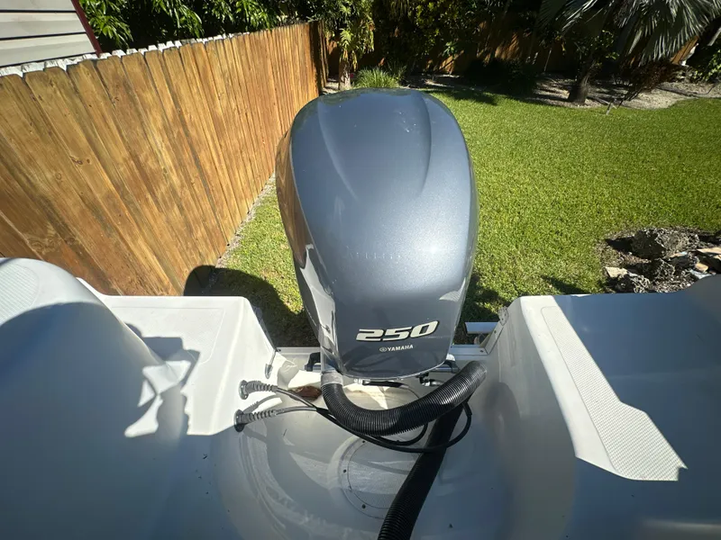 Slide: The Image of 2005 Sailfish 2360 CC boat with Yamaha 250 outboard motor in a backyard setting. - 7