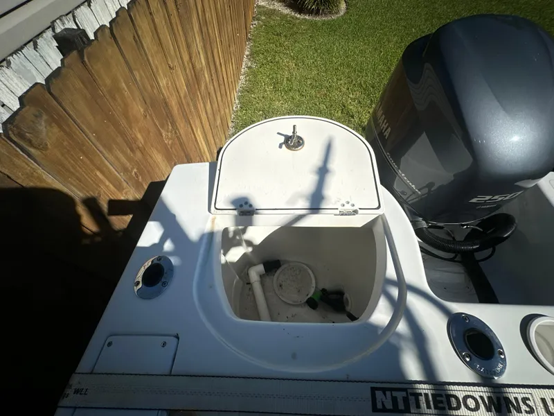 Slide: The Image of 2005 Sailfish 2360 CC boat with open storage compartment and Yamaha engine. - 9