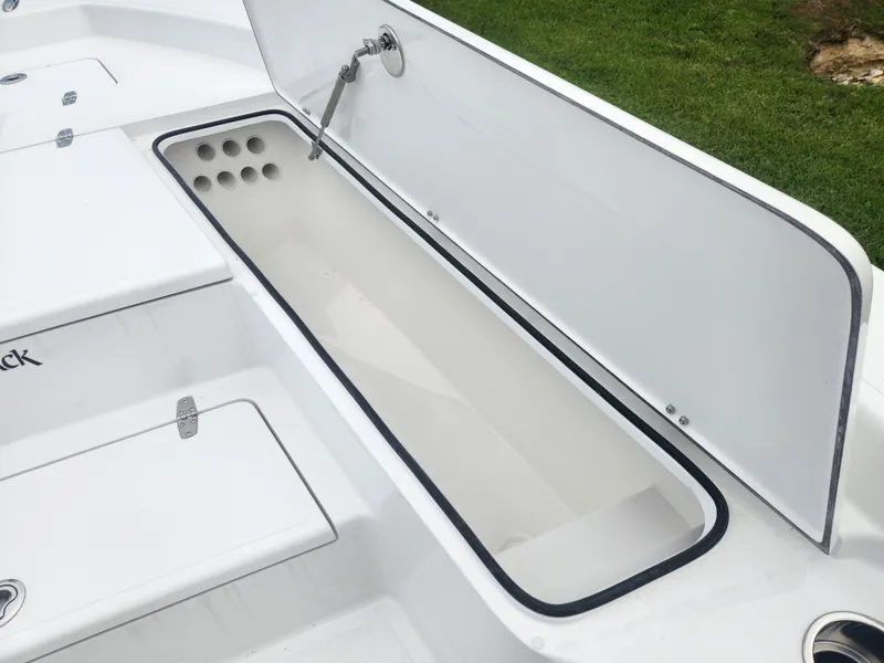 Slide: The Image of Open storage compartment on 2025 BlackJack 256 Bay boat, featuring a sleek white design. - 11