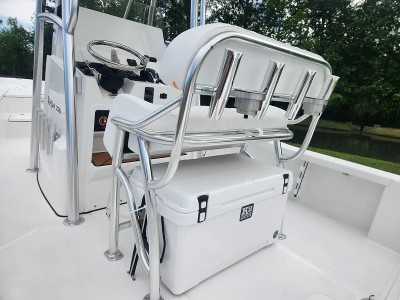 Slide: The Image of 2025 BlackJack 256 Bay boat interior with steering console and cooler. - 16