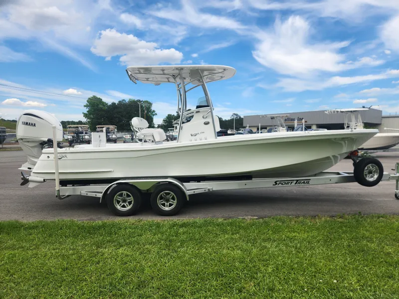 Slide: The Image of 2025 BlackJack 256 Bay boat on trailer, parked outdoors under a blue sky. - 6
