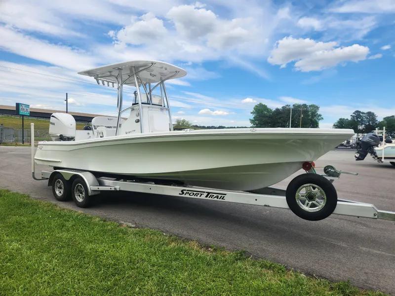 Slide: The Image of 2025 BlackJack 256 Bay boat on Sport Trail trailer under a blue sky. - 7