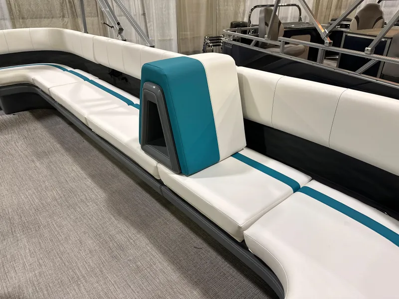 Slide: The Image of 2025 Avalon Aura 21' pontoon boat with modern seating and steering console, parked on trailer. - 4
