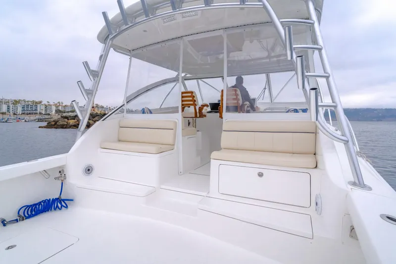 Slide: The Image of 2022 Viking 38 Open Billfish boat with spacious seating and helm, docked near a marina. - 15