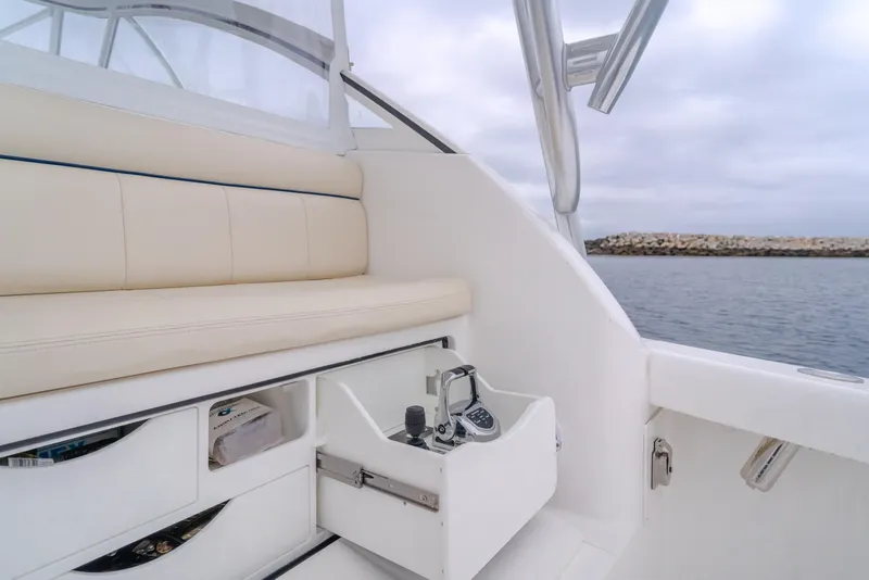 Slide: The Image of 2022 Viking 38 Open Billfish interior with beige seating and control panel, overlooking the water. - 16