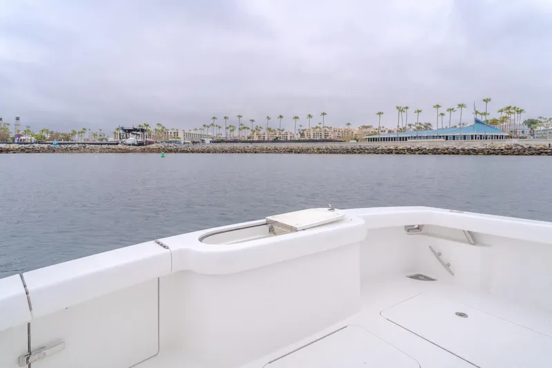 Slide: The Image of 2022 Viking 38 Open Billfish boat on calm water near a coastal cityscape. - 20