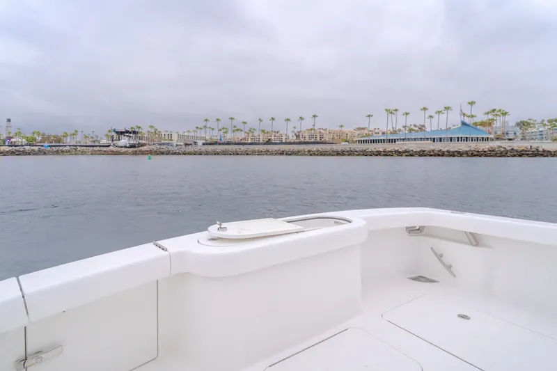 Slide: The Image of 2022 Viking 38 Open Billfish boat on calm water near a coastal cityscape. - 21