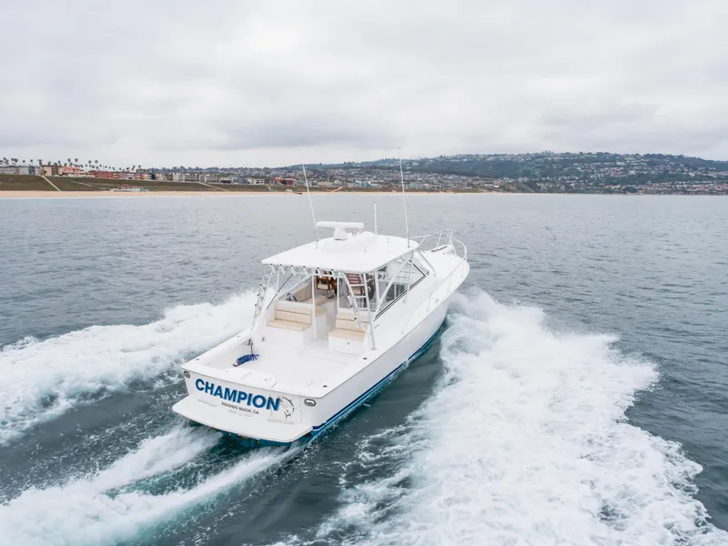 Slide: The Image of 2022 Viking 38 Open Billfish cruising on the ocean near a coastal city. - 32