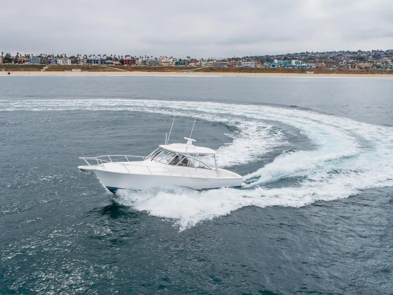 Slide: The Image of 2022 Viking 38 Open Billfish cruising in open water near a coastal city. - 34