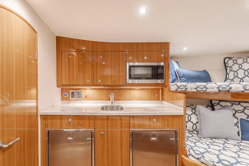 Slide: The Image of 2022 Viking 38 Open Billfish interior with kitchenette, microwave, and bunk beds. - 4