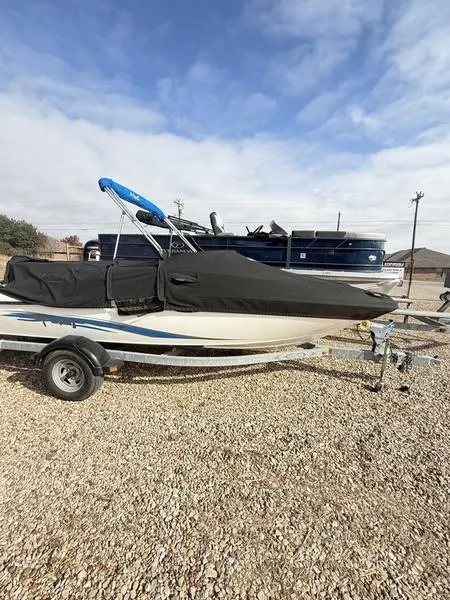 Slide: The Image of 2012 Sea Ray 185 Sport boat on trailer, covered, parked on gravel. - 12