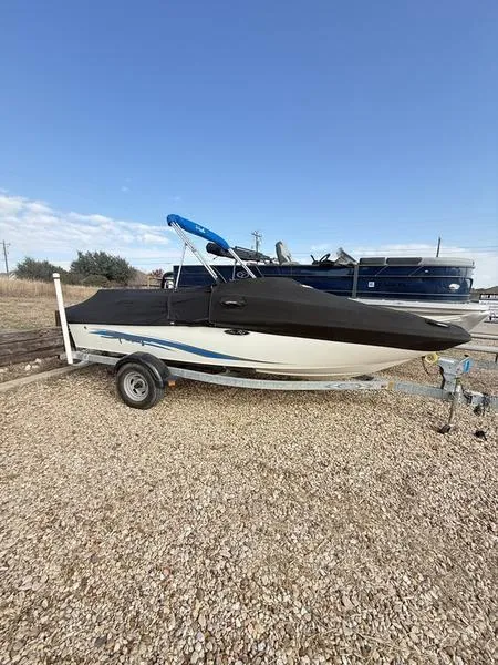 Slide: The Image of 2012 Sea Ray 185 Sport boat on trailer, covered, parked on gravel. - 13
