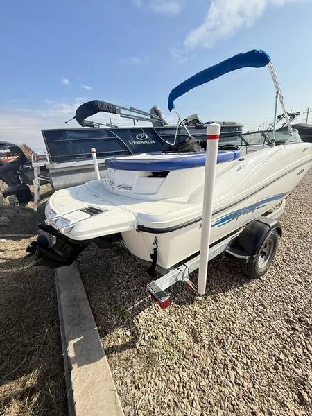 Slide: The Image of 2012 Sea Ray 185 Sport boat on trailer, blue canopy, parked on gravel. - 3