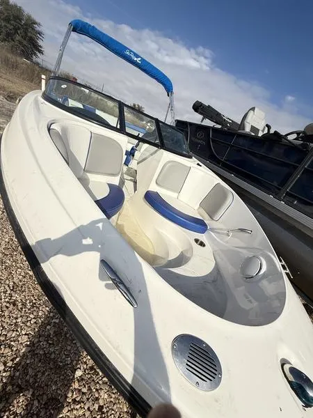 Slide: The Image of 2012 Sea Ray 185 Sport boat with blue canopy, parked on gravel. - 4