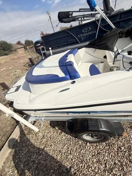 Slide: The Image of 2012 Sea Ray 185 Sport boat on trailer, featuring blue and white seating. - 5