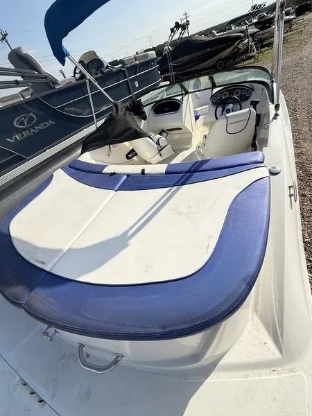 Slide: The Image of 2012 Sea Ray 185 Sport boat with blue and white seating, parked outdoors. - 7