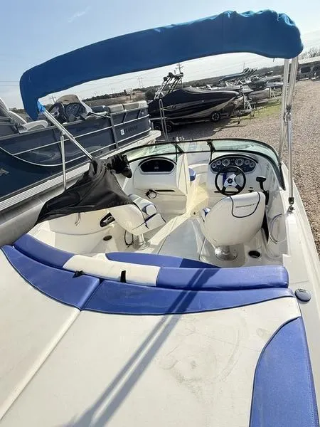Slide: The Image of 2012 Sea Ray 185 Sport boat with blue and white interior, docked outdoors. - 8