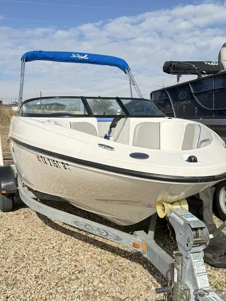 Slide: The Image of 2012 Sea Ray 185 Sport boat on trailer with blue canopy, parked outdoors. - 9
