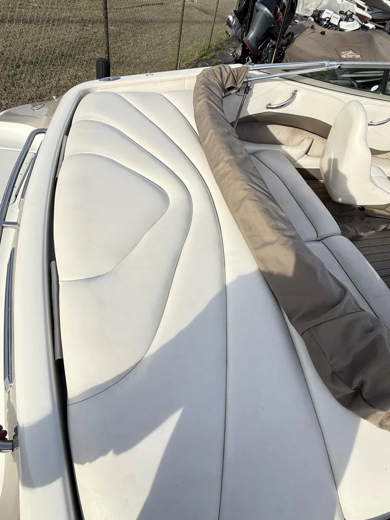 Slide: The Image of 2001 Crownline 202 BR boat interior with white leather seating and protective cover. - 10