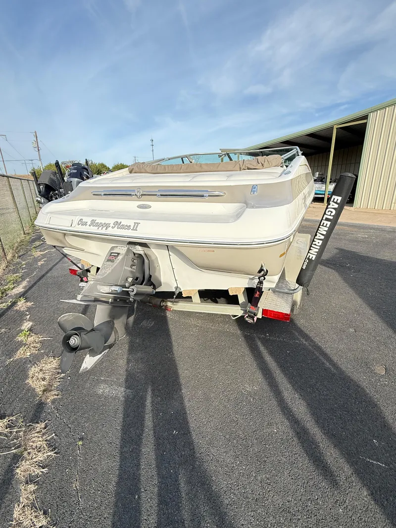 Slide: The Image of 2001 Crownline 202 BR boat on trailer, rear view, outdoors near storage facility. - 2