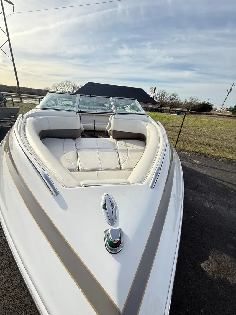 Slide: The Image of 2001 Crownline 202 BR boat with white and beige interior, parked outdoors. - 5