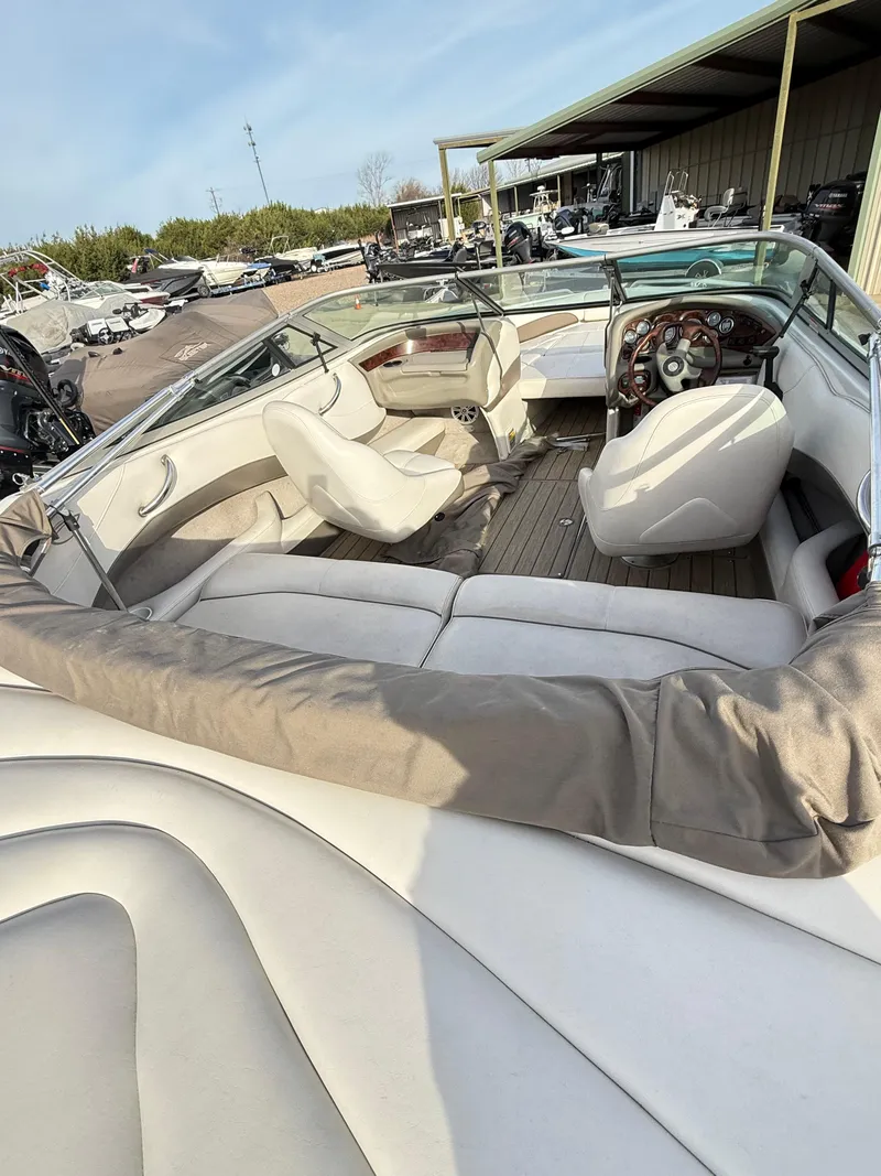 Slide: The Image of 2001 Crownline 202 BR boat interior with white seating and wooden accents. - 9