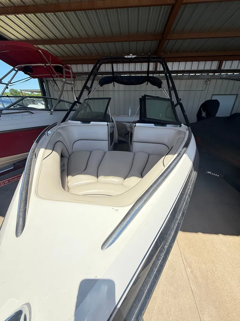 Slide: The Image of 2002 Malibu 21 LSV boat with beige interior, stored in a covered area. - 17