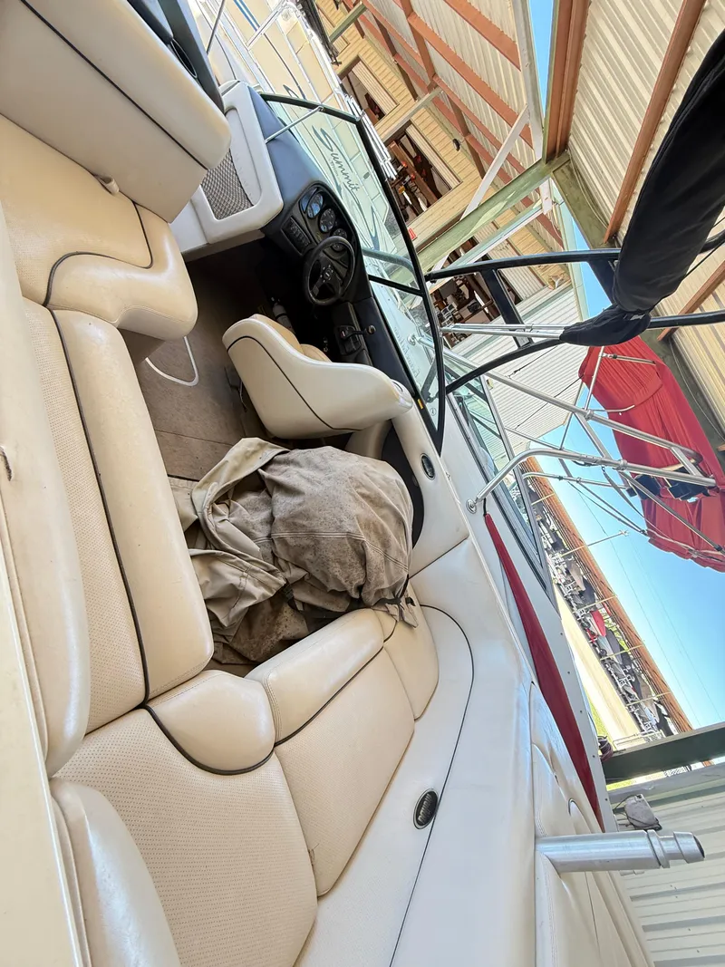 Slide: The Image of Interior of a 2002 Malibu 21 LSV boat with beige seating and dashboard. - 18