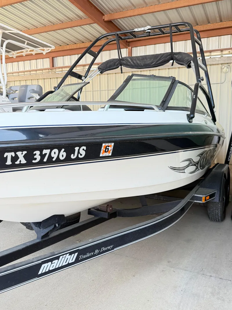 Slide: The Image of 2002 Malibu 21 LSV boat on trailer, parked in covered area. - 2