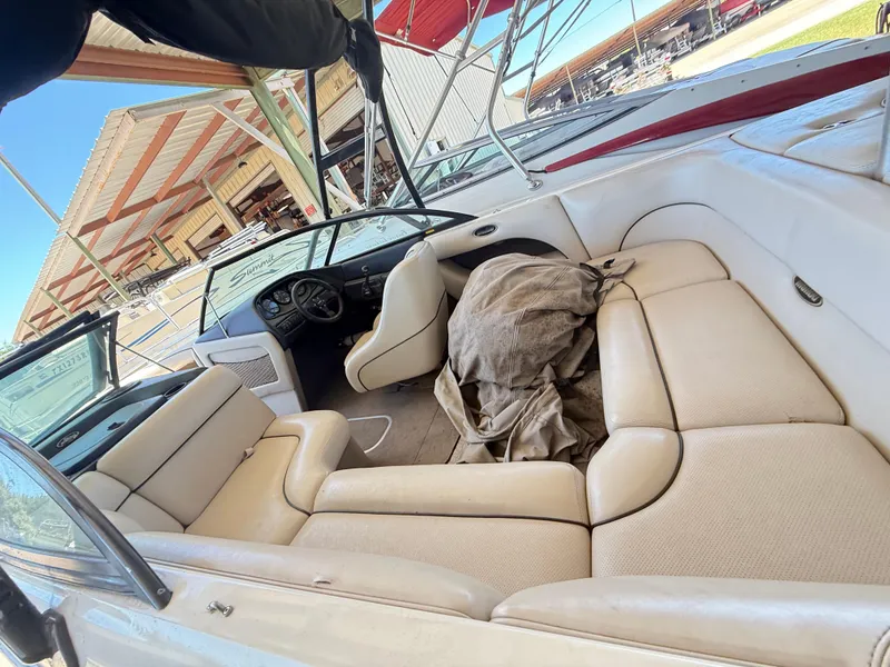 Slide: The Image of Interior of a 2002 Malibu 21 LSV boat with beige seating and covered dashboard. - 20