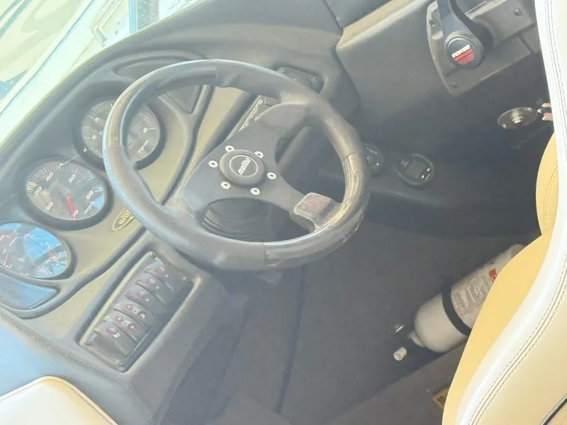Slide: The Image of 2002 Malibu 21 LSV boat dashboard with steering wheel and gauges. - 21