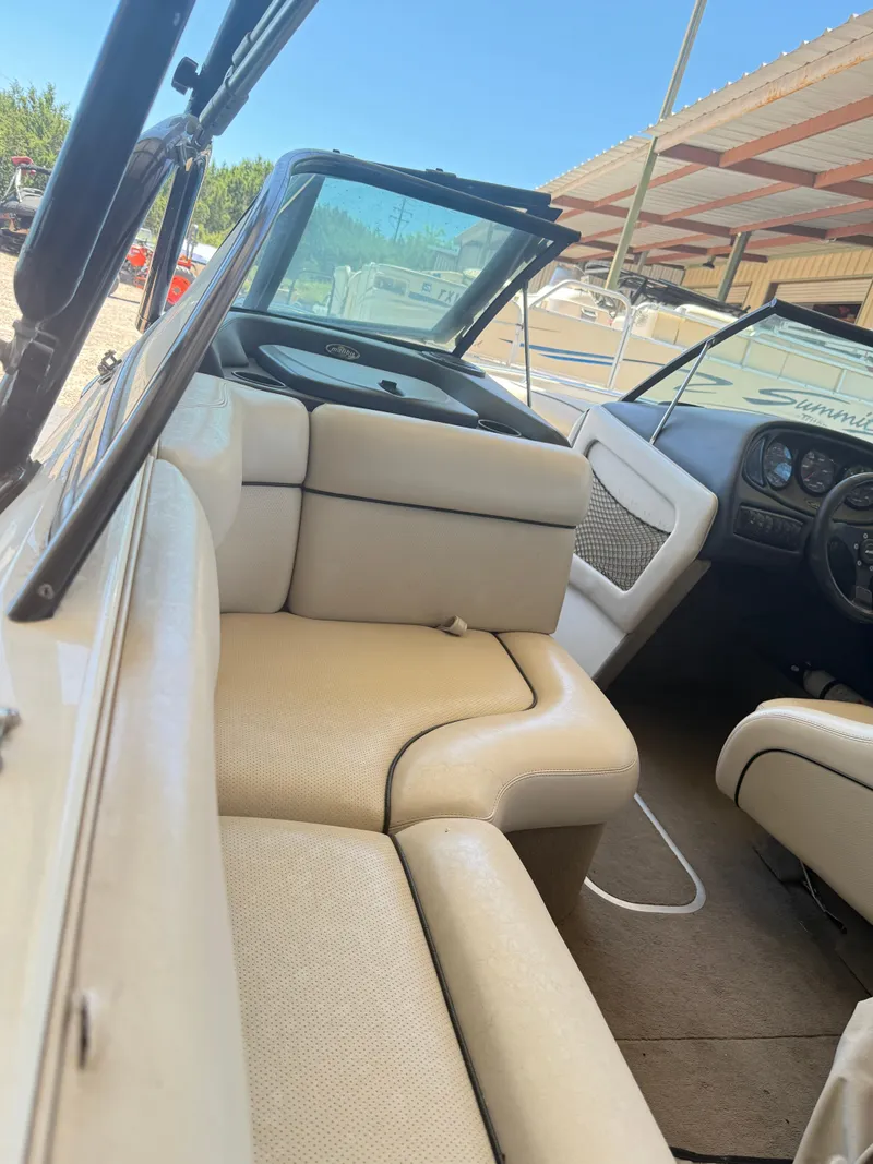 Slide: The Image of Interior of a 2002 Malibu 21 LSV boat with beige seating and dashboard. - 23