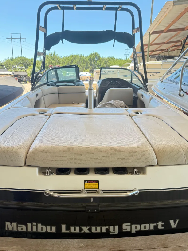 Slide: The Image of 2002 Malibu 21 LSV boat with beige seating and wakeboard tower. - 24