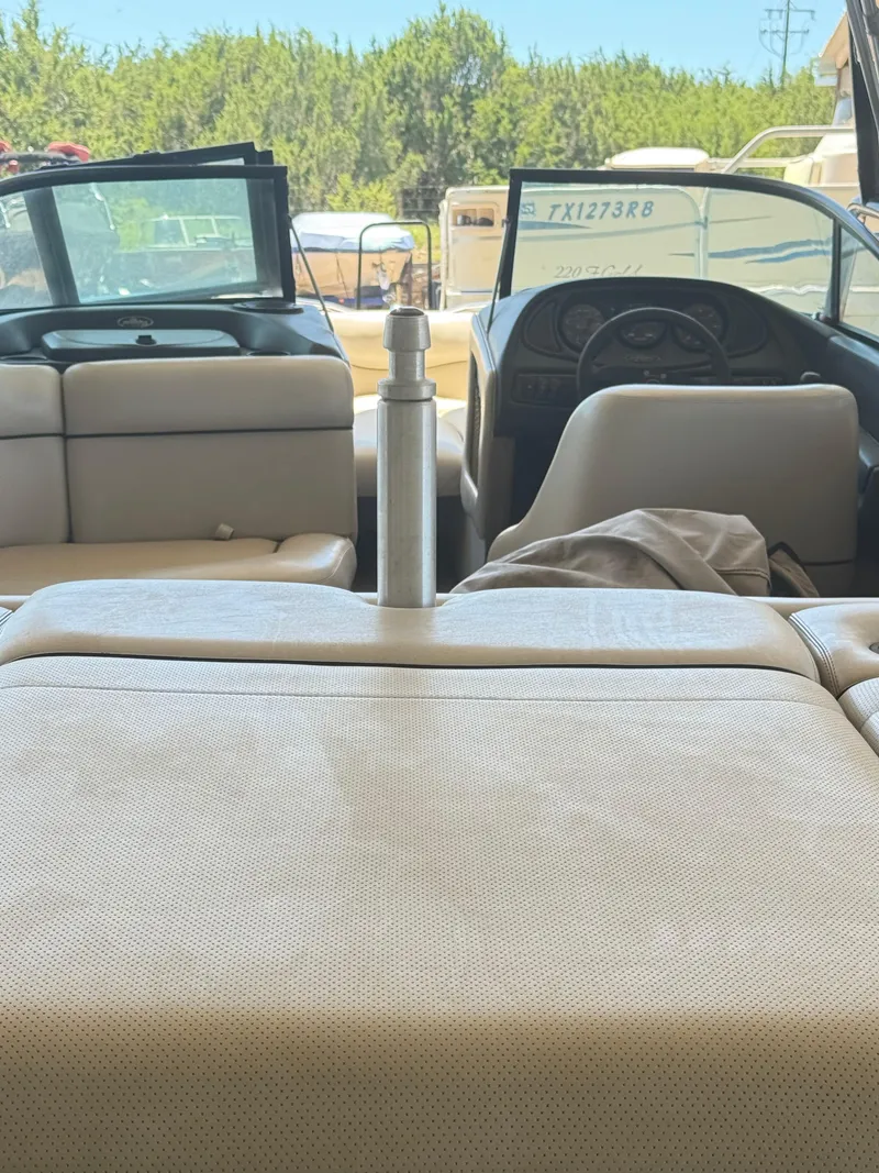 Slide: The Image of Interior view of a 2002 Malibu 21 LSV boat with beige seating and dashboard. - 25