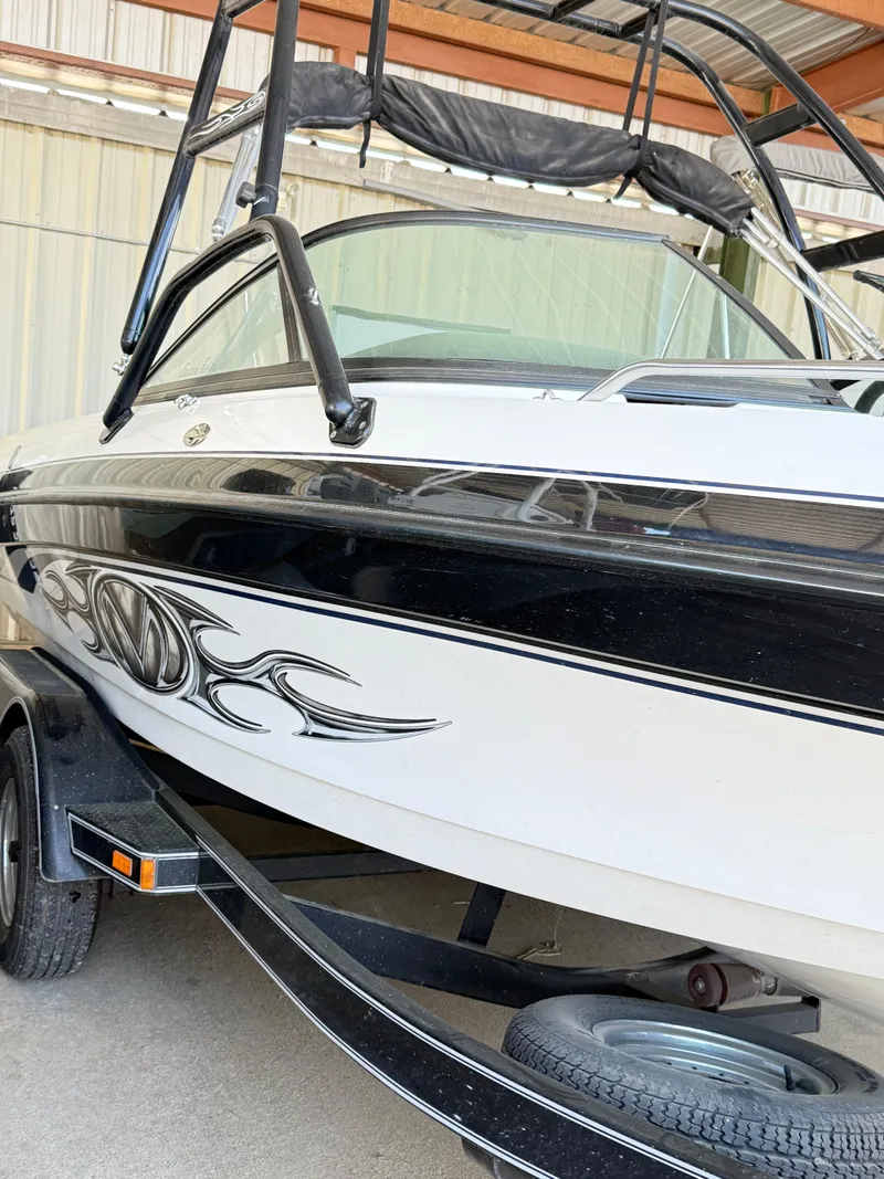 Slide: The Image of 2002 Malibu 21 LSV boat with black and white design in a storage area. - 3