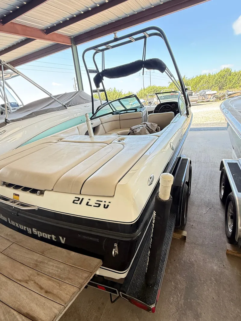 Slide: The Image of 2002 Malibu 21 LSV boat in storage, featuring a sleek design and comfortable seating. - 4