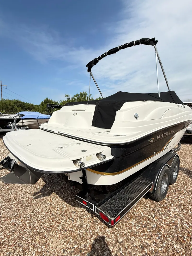 Slide: The Image of 2002 Regal 2120 Destiny boat on trailer, featuring sleek design and black canopy. - 4