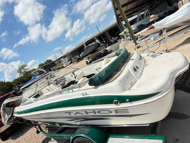 Slide: The Image of 2006 Tracker Q-4 Fish and Ski boat in storage, green and white exterior, sunny day. - 4