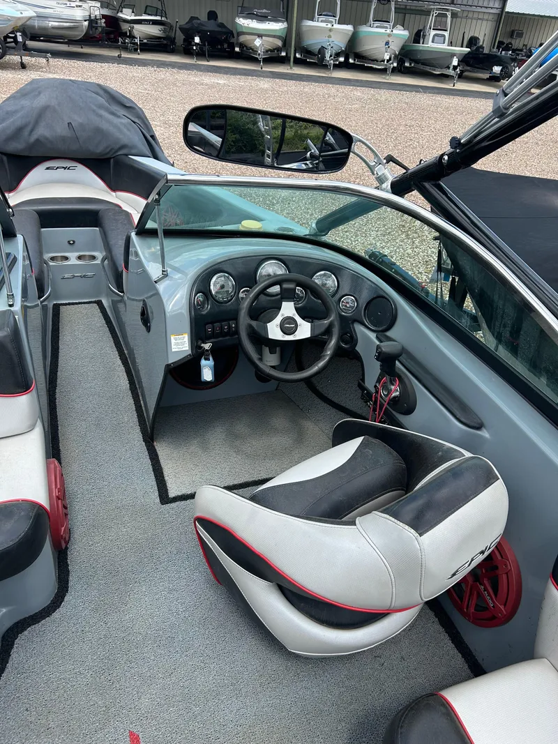 Slide: The Image of Interior of a 2012 Epic 23V boat, featuring steering wheel and seating. - 11